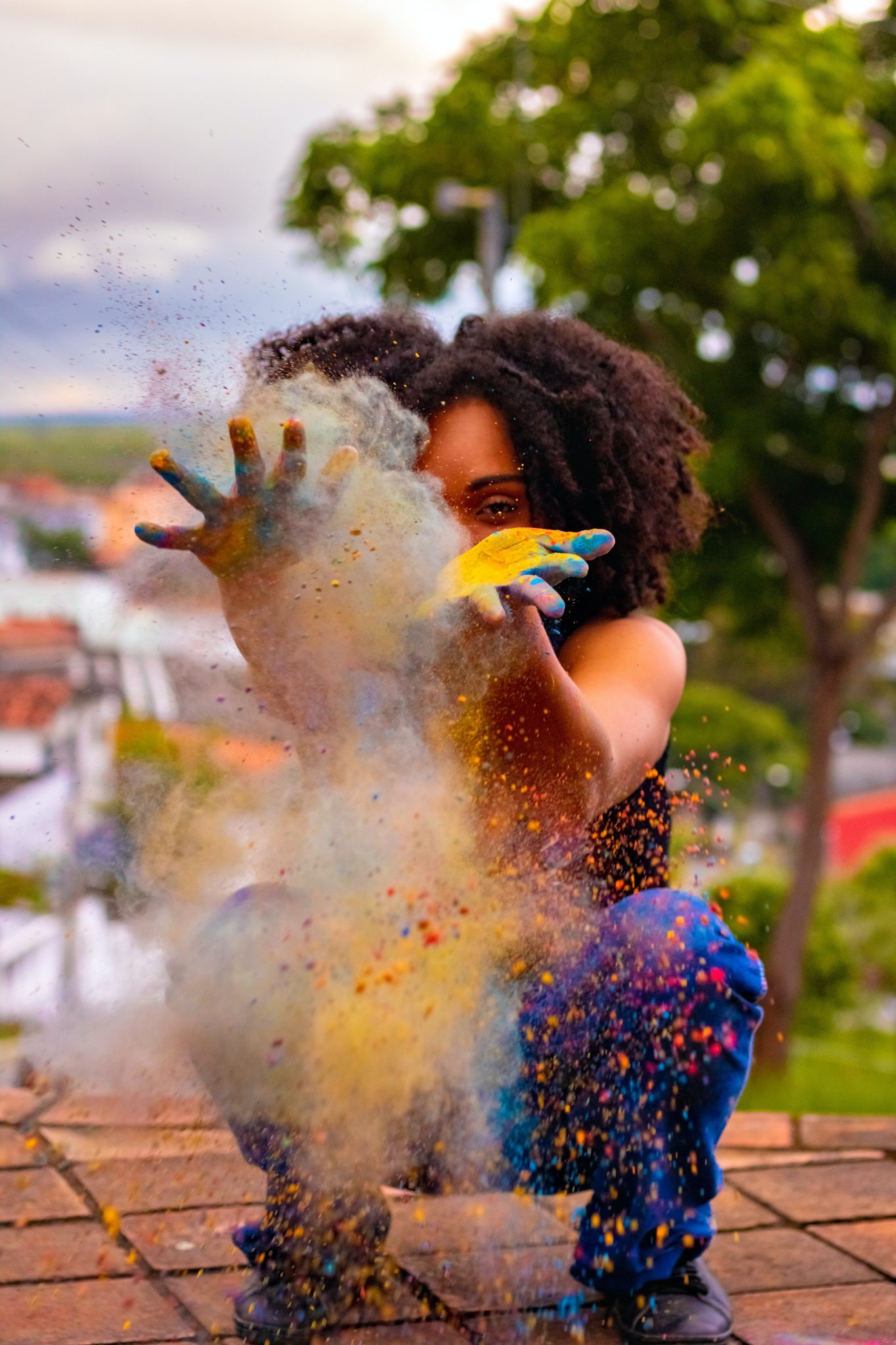 femme qui lance des poudres de couleurs car elle a développé son potentiel créatif